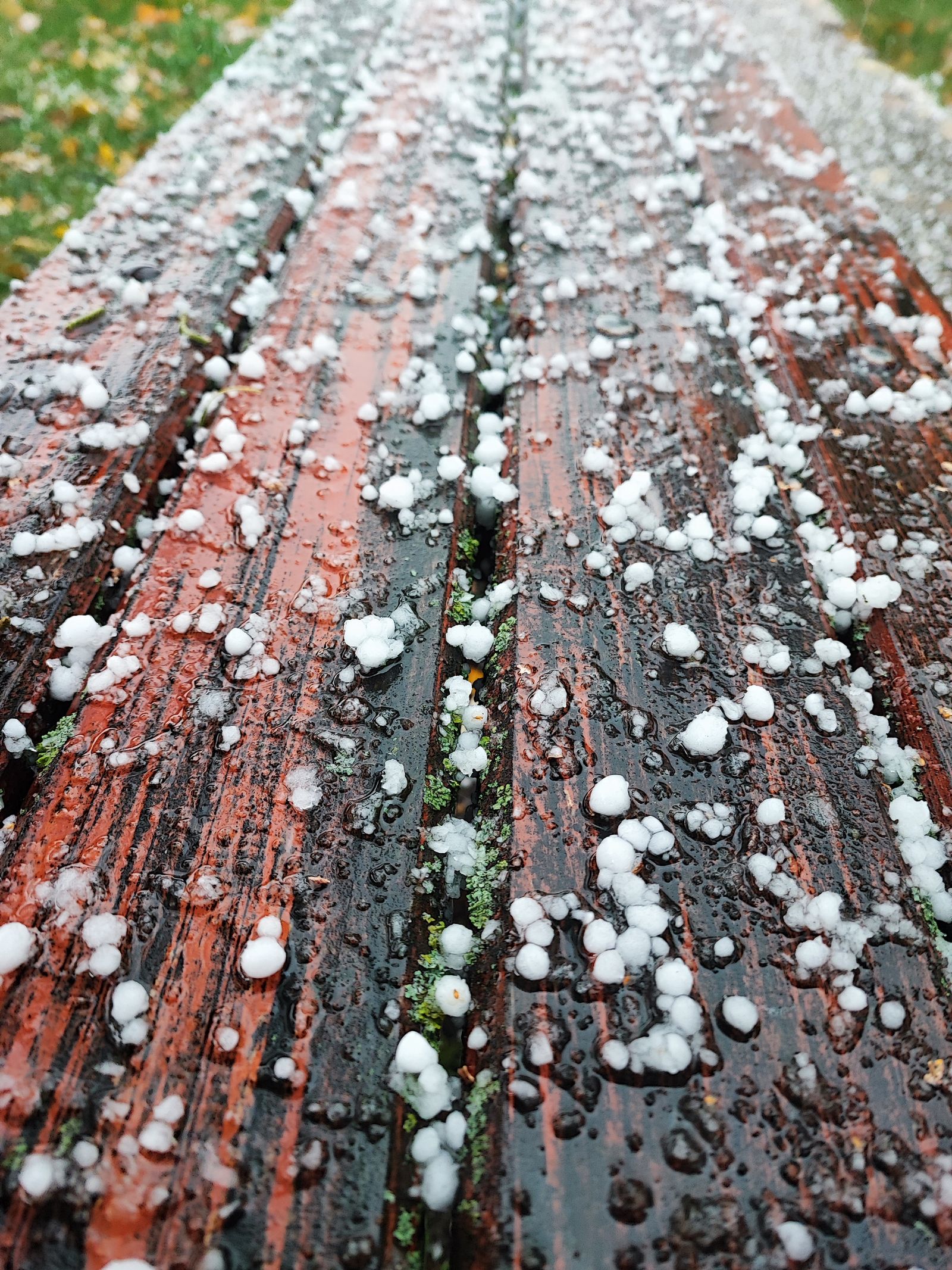 Hailstones scattered on a wooden surface after a storm