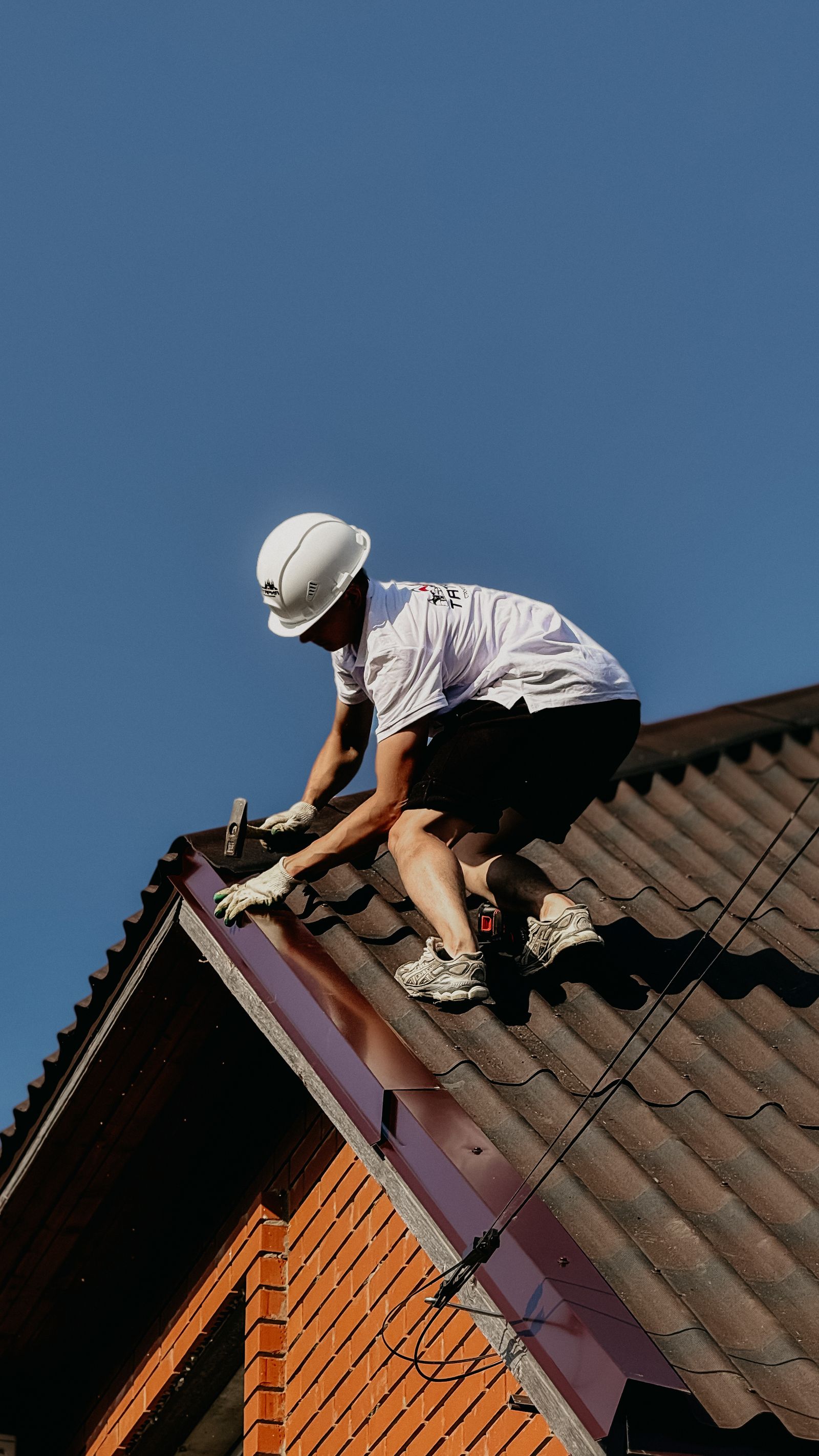 Professional roofer working safely on a building roof
